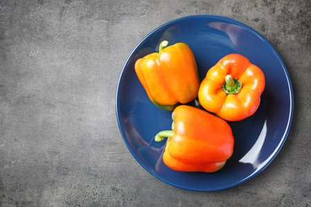 Plate with ripe paprika peppers on gray background, top viewの写真素材