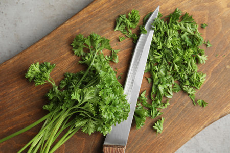 Wooden board with fresh green parsley and knife on table, top viewの写真素材