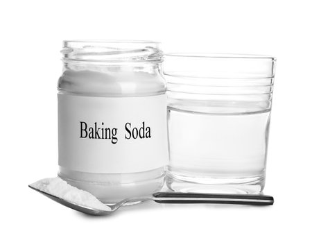 Glass of water, jar with baking soda and spoon on white backgroundの写真素材