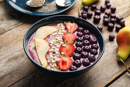 Bowl with tasty acai smoothie on wooden tableの写真素材