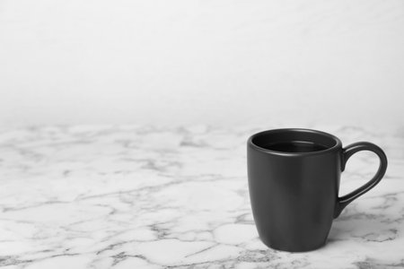 Black ceramic cup with hot aromatic coffee on tableの写真素材