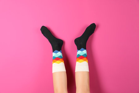 Woman wearing stylish socks on color backgroundの写真素材