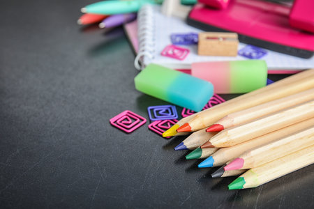 Different colorful stationery on chalkboard surface. back to schoolの写真素材