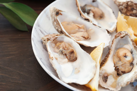 Fresh oysters and cut juicy lemon served on table, closeupの写真素材