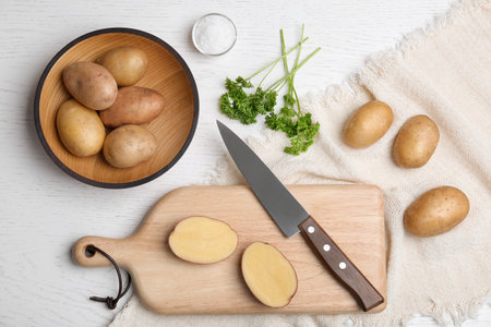 Flat lay composition with fresh ripe organic potatoes on white wooden backgroundの写真素材