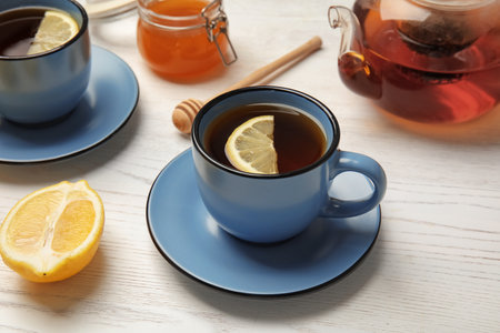 Cup with black tea and lemon on tableの写真素材
