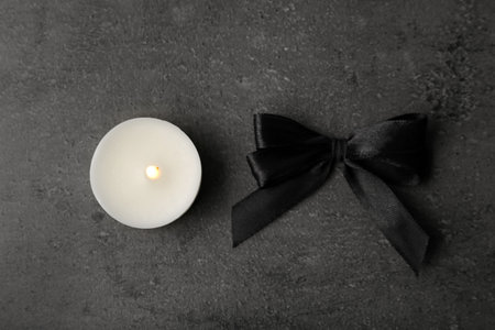 Black ribbon and candle on gray background, top view. funeral symbolsの写真素材