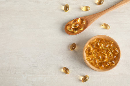 Flat lay composition with cod liver oil pills and space for text on light backgroundの写真素材