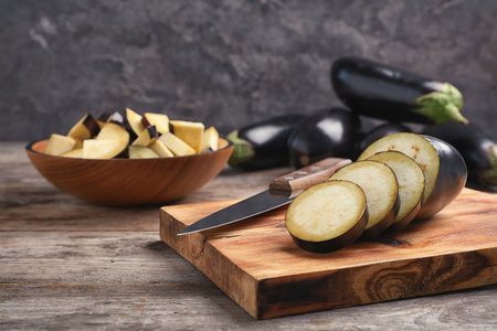 Wooden board with cut eggplant on tableの写真素材