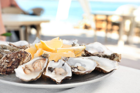 Fresh oysters with cut juicy lemon served on tableの写真素材