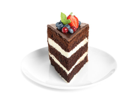 Plate with slice of chocolate sponge berry cake on white background
