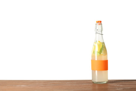 Bottle with natural lemonade on table against white backgroundの写真素材
