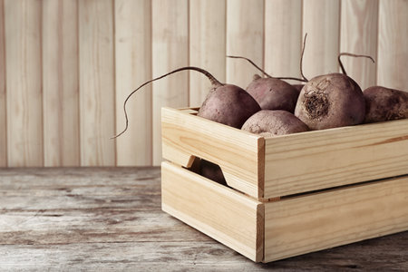 Box with whole fresh beets on wooden tableの写真素材