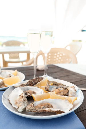 Fresh oysters with cut juicy lemon served on tableの写真素材