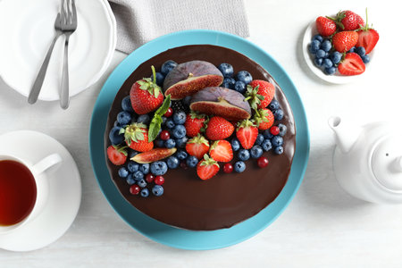 Fresh delicious homemade chocolate cake with berries on light table, flat layの写真素材