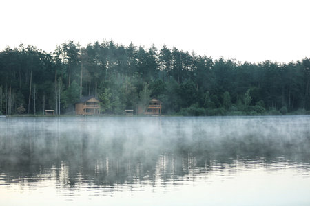 Beautiful landscape with forest and houses near the lake. camping seasonの写真素材