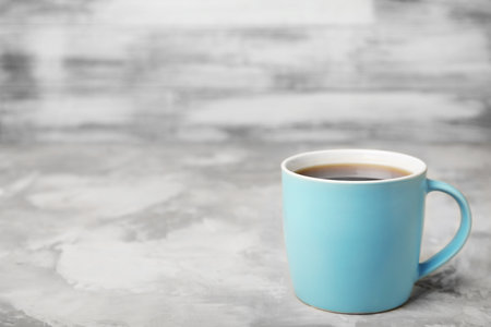Blue ceramic cup with hot aromatic coffee on tableの写真素材