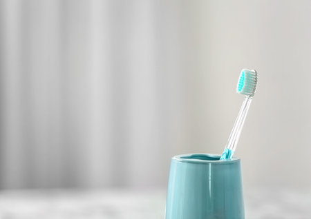 Cup with toothbrush against blurred background. dental careの写真素材