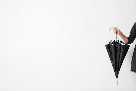 Person holding umbrella on white background with space for designの写真素材