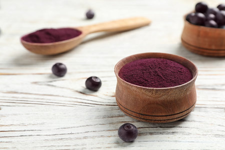 Bowl with acai powder on wooden tableの写真素材