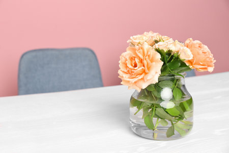 Vase with blooming flowers on table indoorsの写真素材