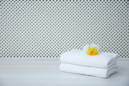 Stack of towels on table against light backgroundの写真素材