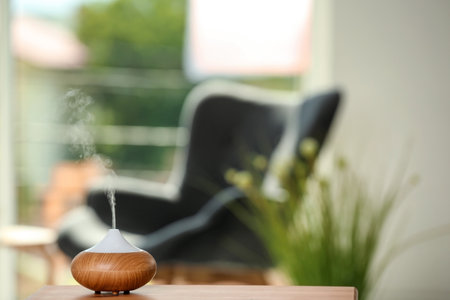 Aroma oil diffuser lamp on table against blurred backgroundの写真素材