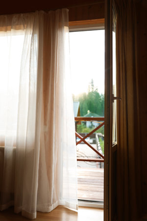 Open balcony door with curtain in apartmentの写真素材