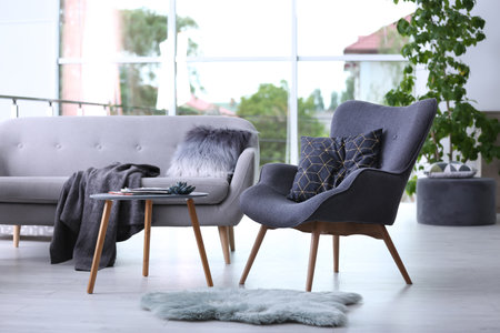 Stylish living room interior with comfortable armchair and sofaの写真素材