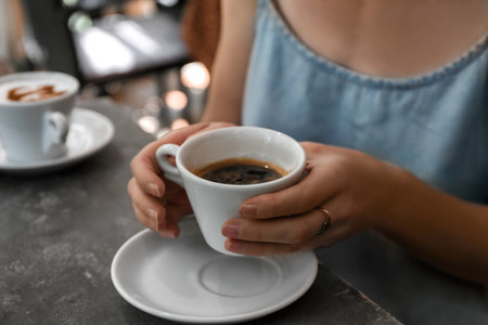 Woman with cup of fresh aromatic coffee at table, closeupの写真素材