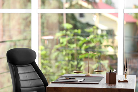 Table with scales of justice in lawyer's officeの写真素材