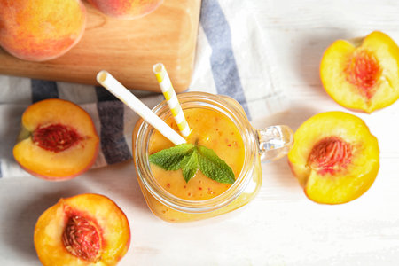 Tasty peach smoothie in mason jar on table, top viewの写真素材