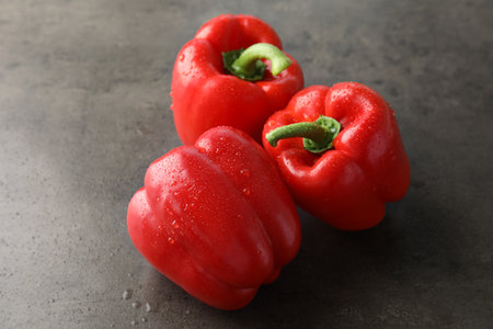 Raw ripe paprika peppers on gray backgroundの写真素材