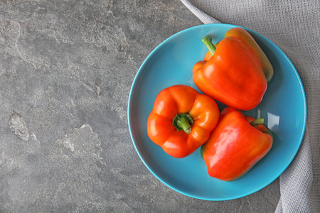 Plate with ripe paprika peppers on gray background, top viewの写真素材
