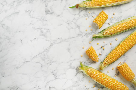 Tasty sweet corn cobs on marble table, top viewの写真素材