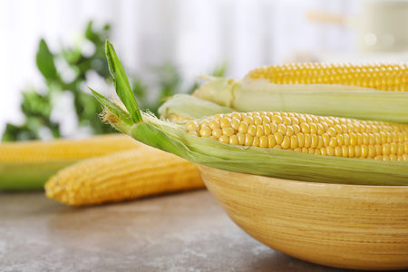 Bowl with tasty sweet corn cobs on table, closeupの写真素材