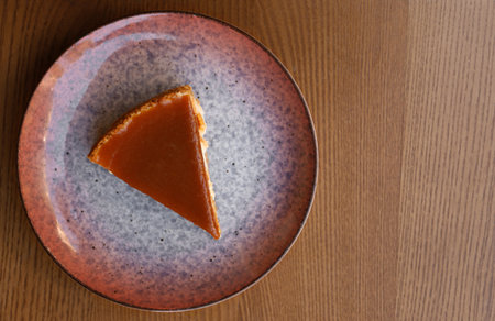 Plate with slice of cake on wooden table, top viewの写真素材