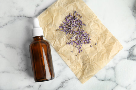 Natural herbal oil and lavender on marble background, top viewの写真素材