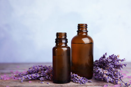 Bottles with aromatic lavender oil on wooden tableの写真素材