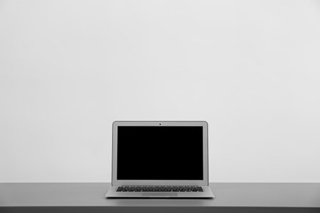 Modern laptop with blank screen on table against light backgroundの写真素材