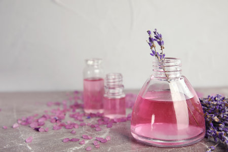 Bottles with aromatic lavender oil on gray table. Space for textの写真素材