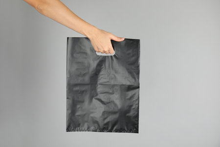 Woman with plastic bag on gray background. Mock up design