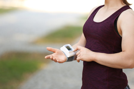 Young woman checking pulse after workout, focus on handsの写真素材