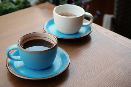 Cups of fresh aromatic coffee on wooden tableの写真素材