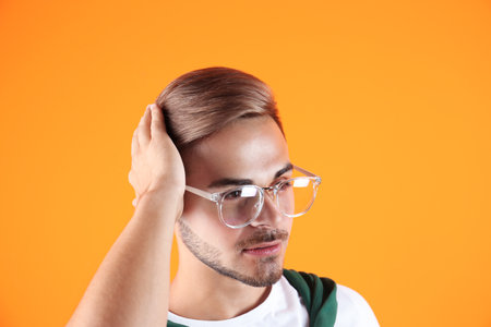Young man with trendy hairstyle on color backgroundの写真素材