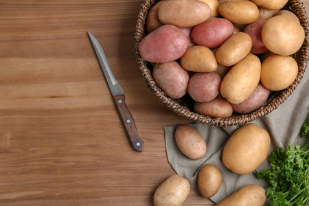 Flat lay composition with fresh organic potatoes and space for text on wooden backgroundの写真素材
