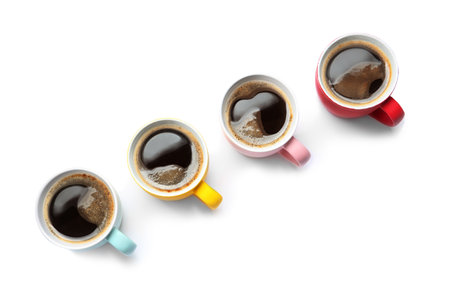 Row of cups with aromatic coffee on white background, top viewの写真素材