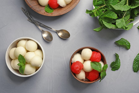 Flat lay composition with mint, melon and watermelon balls on gray background