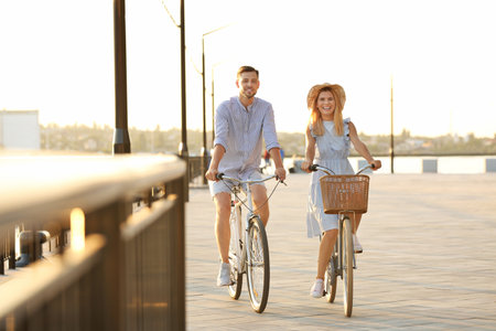 Happy couple riding bicycles outdoors on summer dayの写真素材
