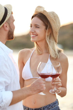 Young couple with glasses of wine on the beachの写真素材